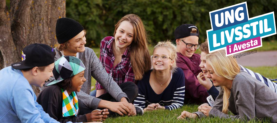 Glada ungdomar ligger på gräset och pratar